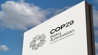 Sign for COP29 climate conference in Baku, Azerbaijan, featuring event logo against a clear blue sky.